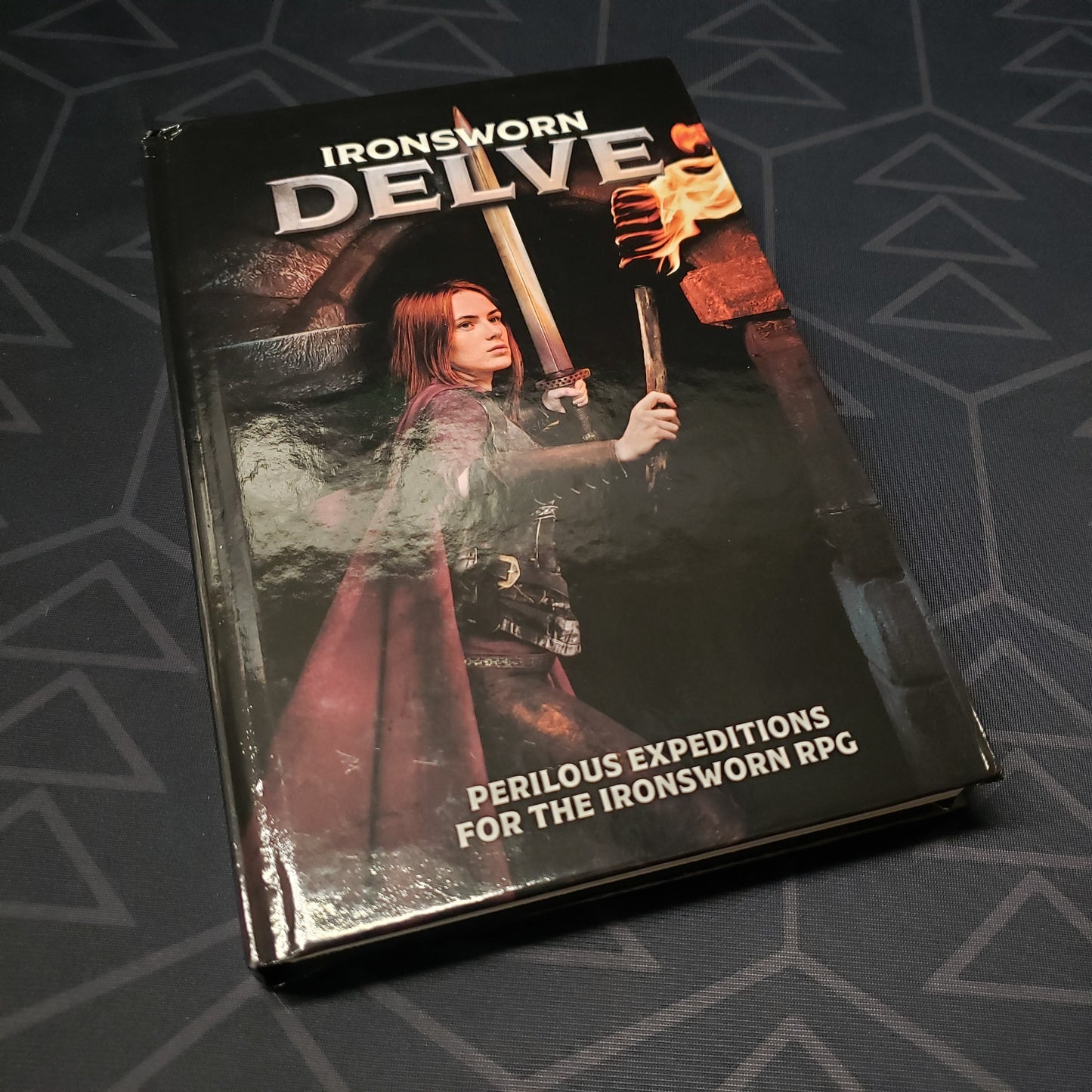 Image shows the front cover of the Delve book for the roleplaying game Ironsworn