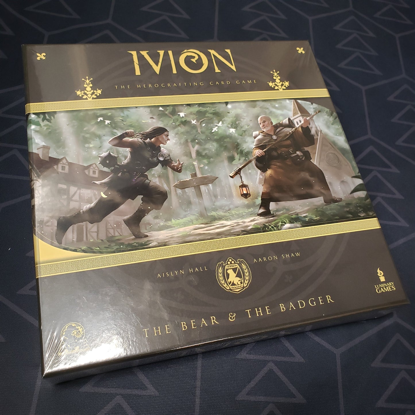 Image shows the front cover of the box for the card game Ivion: The Bear and The Badger