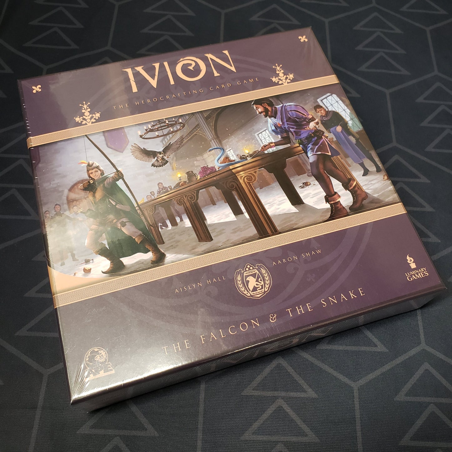 Image shows the front cover of the box for the card game Ivion: The Falcon and The Snake