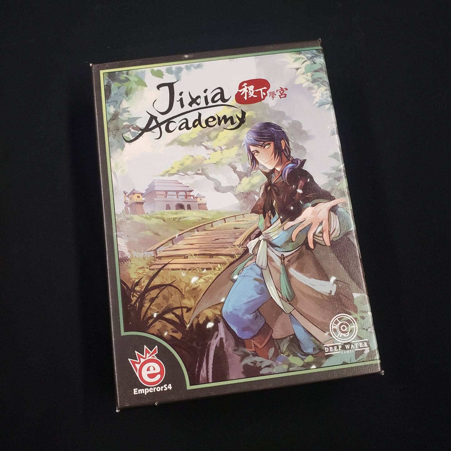 Image shows the front cover of the box of the Jixia Academy card game