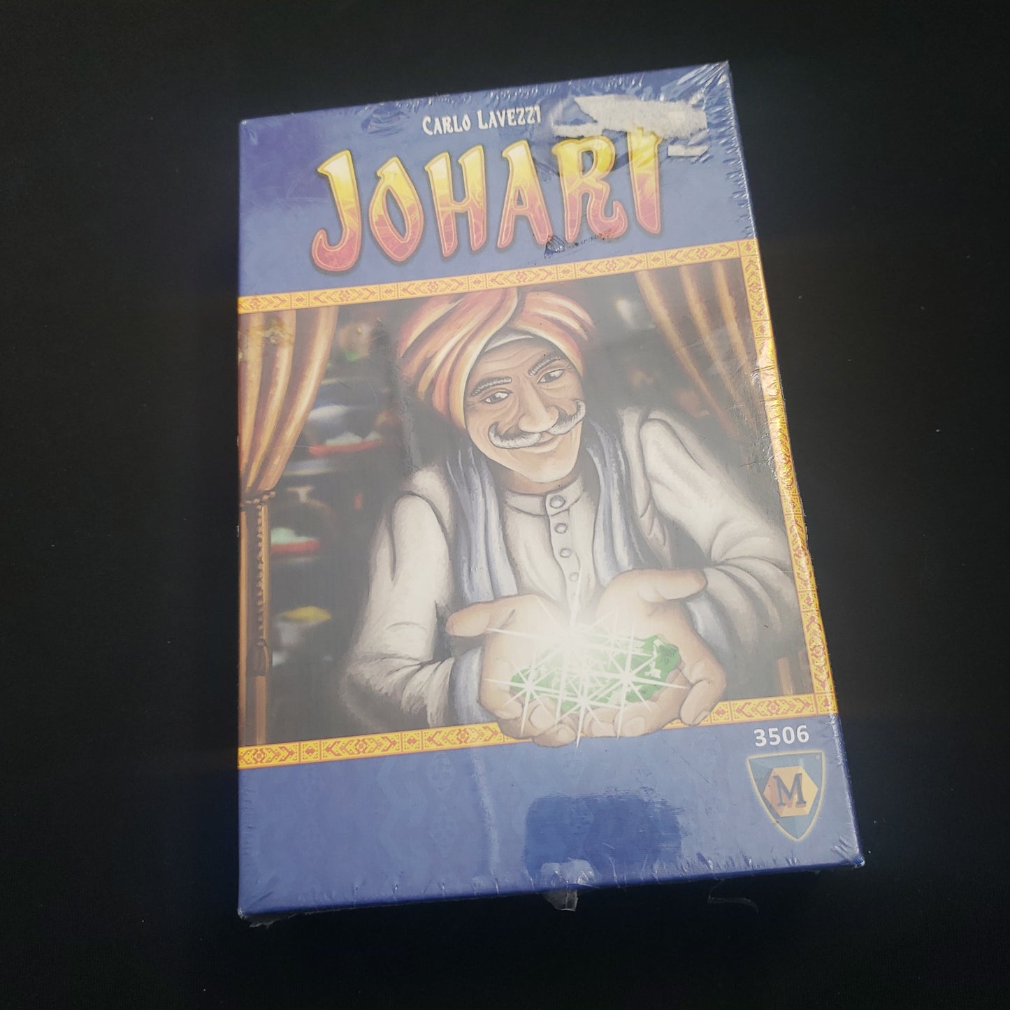 Image shows the front cover of the box of the Johari board game