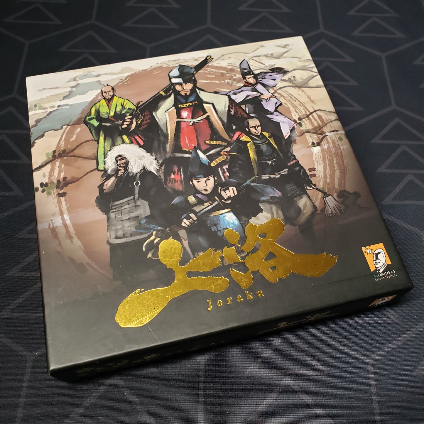 Image shows the front cover of the box for the Joraku (Multilingual Deluxe Edition) card game