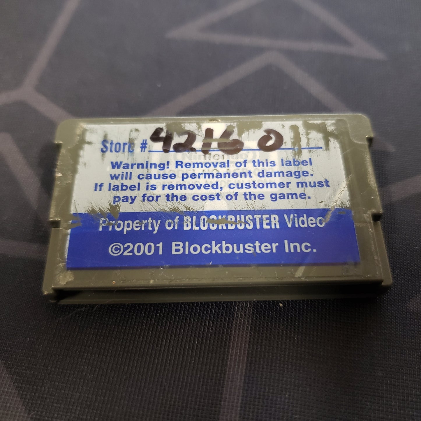 Image shows a Blockbuster sticker on the back of the cartridge of the video game Jurassic Park III: Island Attack for Nintendo Game Boy Advance