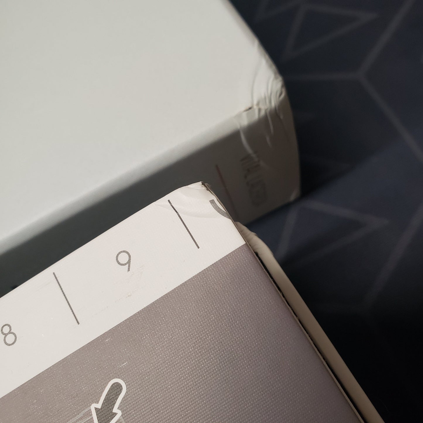 Image shows a dinged corner of the box and a matching corner ding on the board for the Kanban EV board game