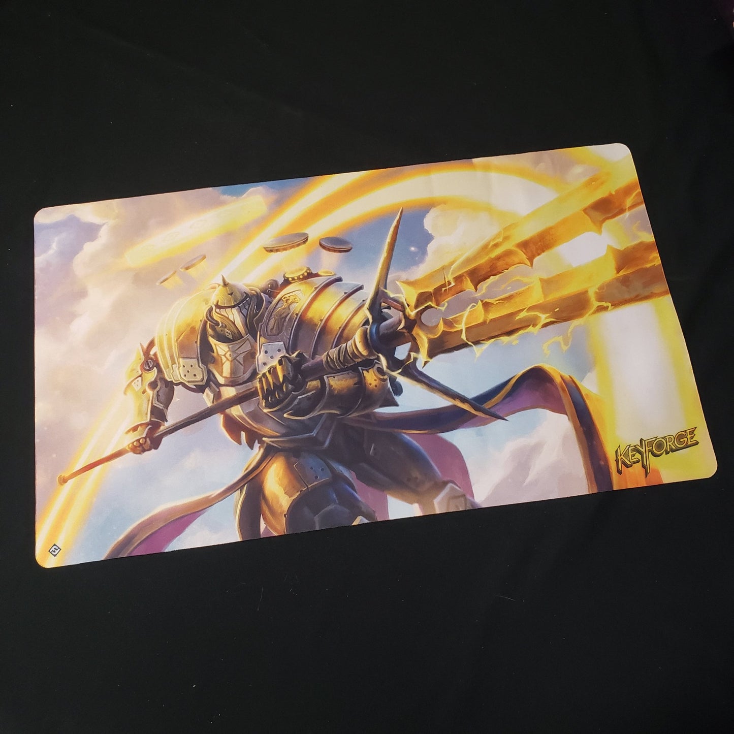 Image shows a playmat featuring the Raiding Knight artwork for the card game Keyforge