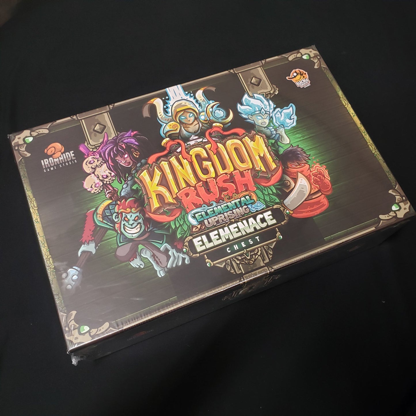 Image shows the front cover of the box of the Elemenace Chest for the board game Kingdom Rush: Elemental Uprising