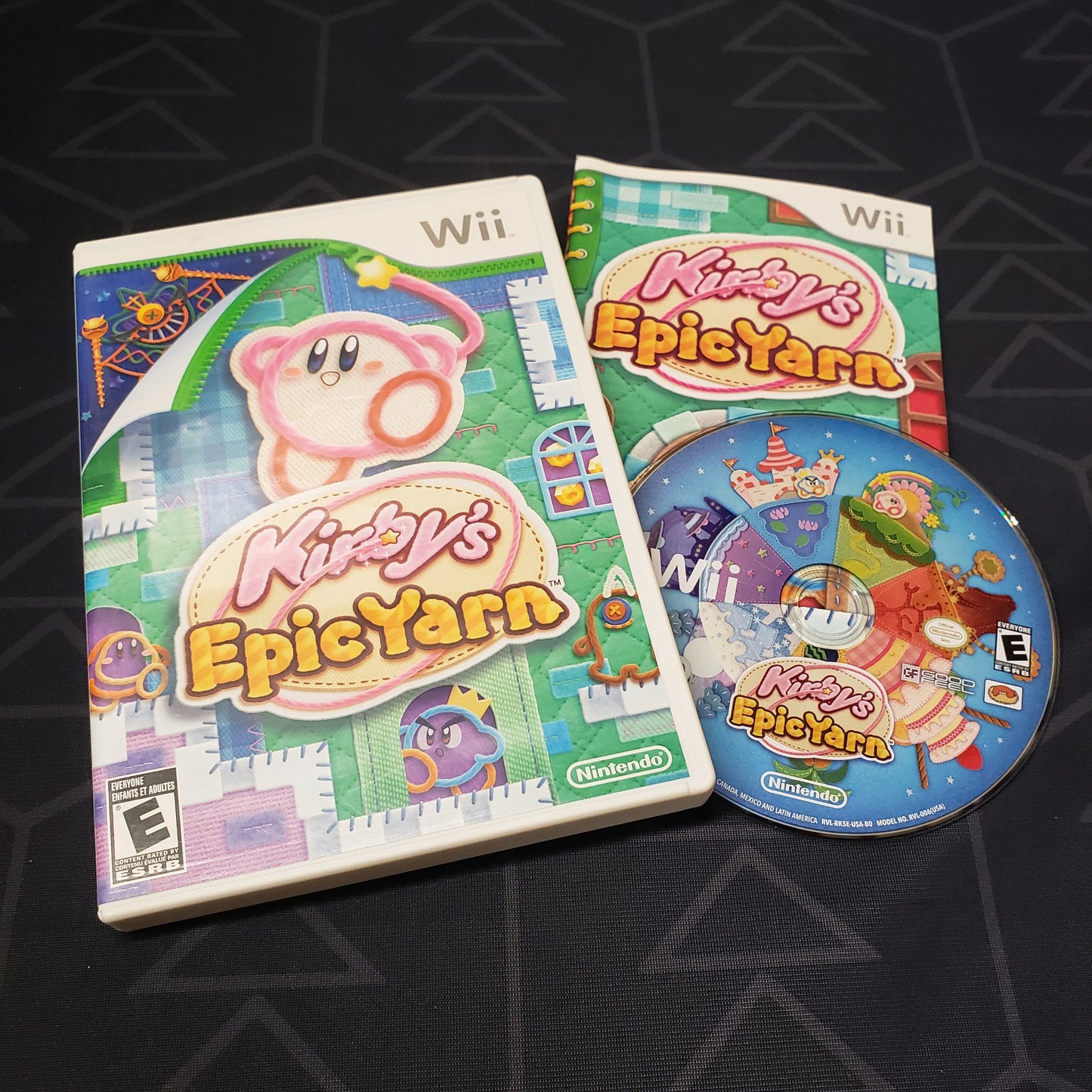 Image shows the case, manual and disc for the video game Kirby's Epic Yarn for Nintendo Wii