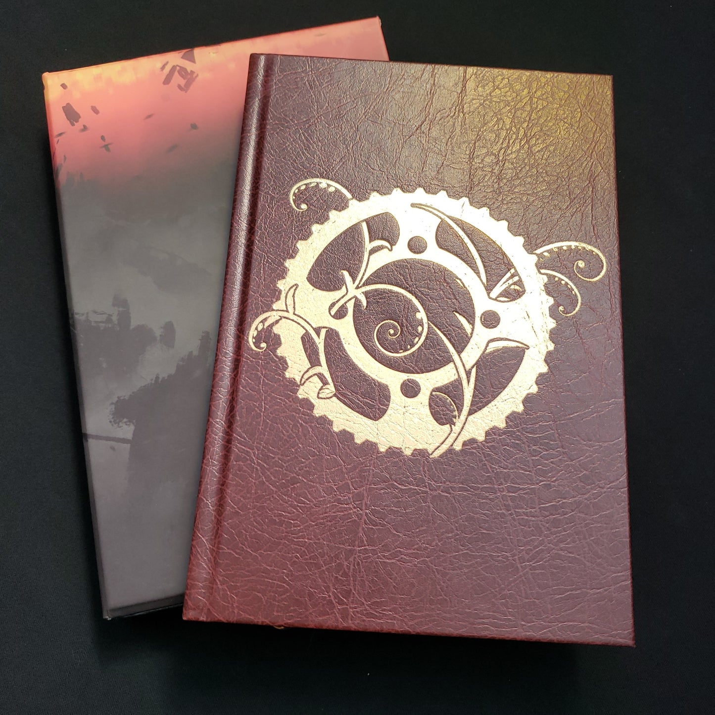 Image shows the front cover of the Legacy: Life Among the Ruins roleplaying game book, sitting op top of its slipcover box