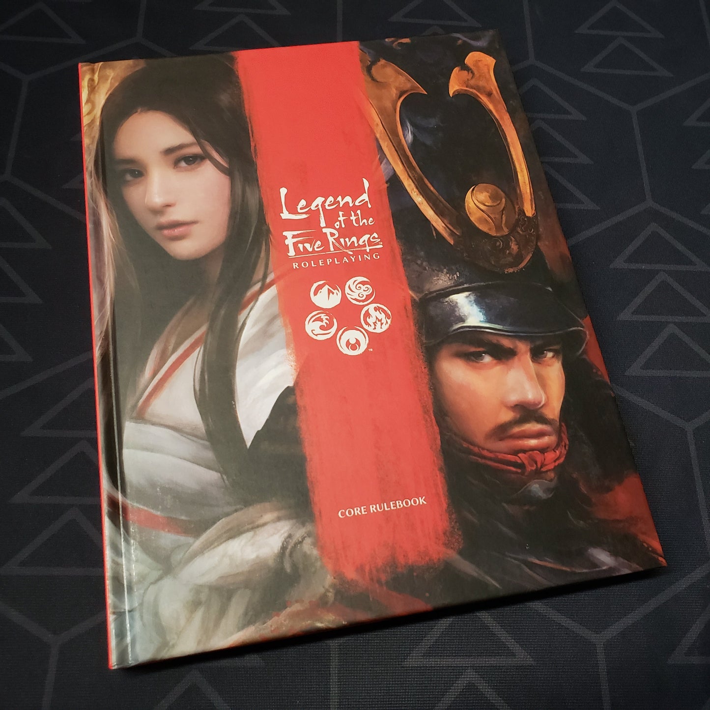 Image shows the front cover of the core rulebook for the roleplaying game Legend of the Five Rings: Fifth Edition