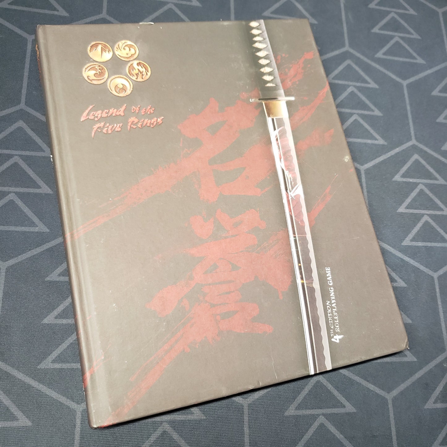 Image shows the front cover of the core rulebook for the roleplaying game Legend of the Five Rings: Fourth Edition
