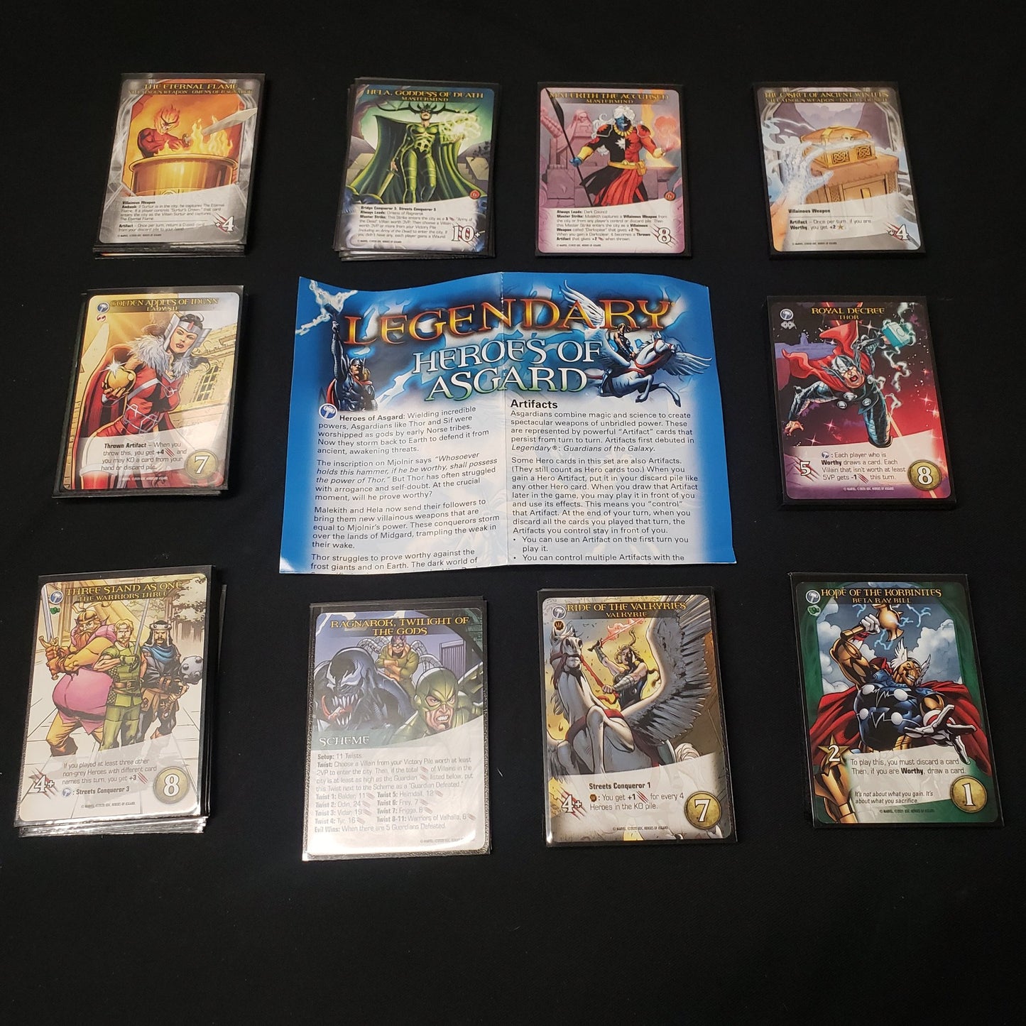 Image shows the instructions & cards arranged in stacks by card type for the Heroes of Asgard expansion for the board game Legendary Marvel