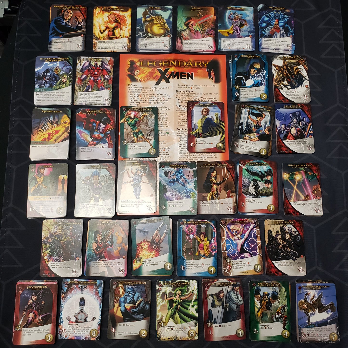 Image shows the instructions & cards arranged in stacks by card type for the X-Men expansion for the card game Legendary Marvel