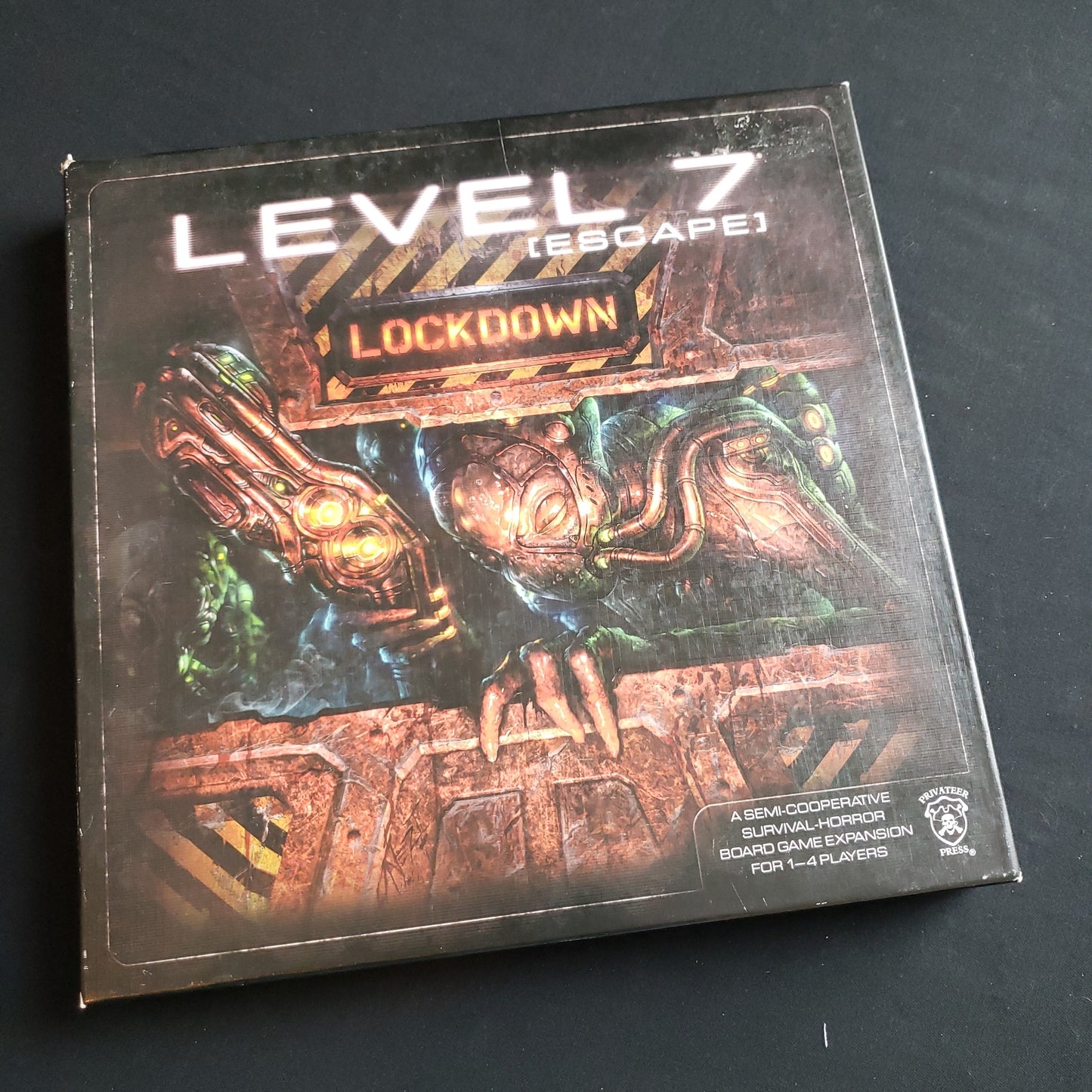 Image shows the front cover of the box of the Lockdown expansion for the Level 7: Escape board game