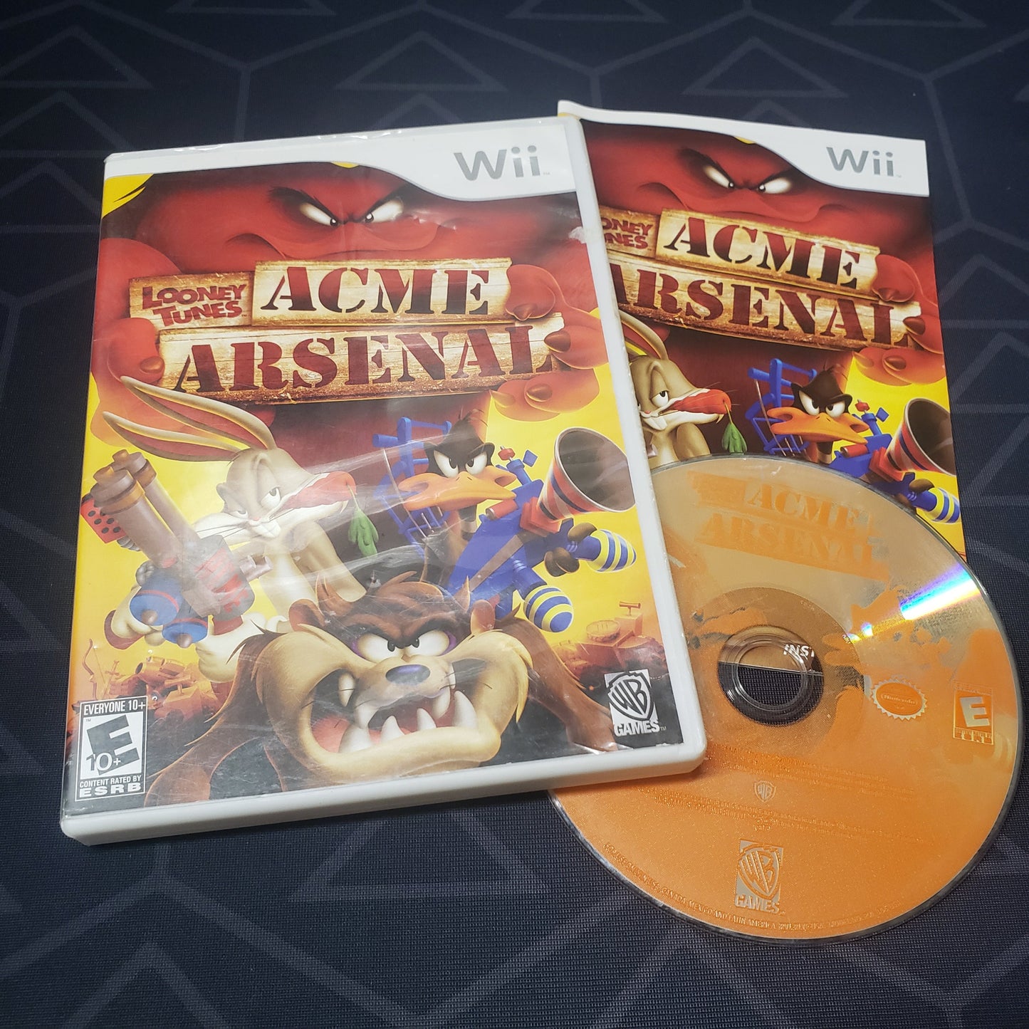 Image shows the case, manual & disc for the video game Looney Tunes: Acme Arsenal for Nintendo Wii