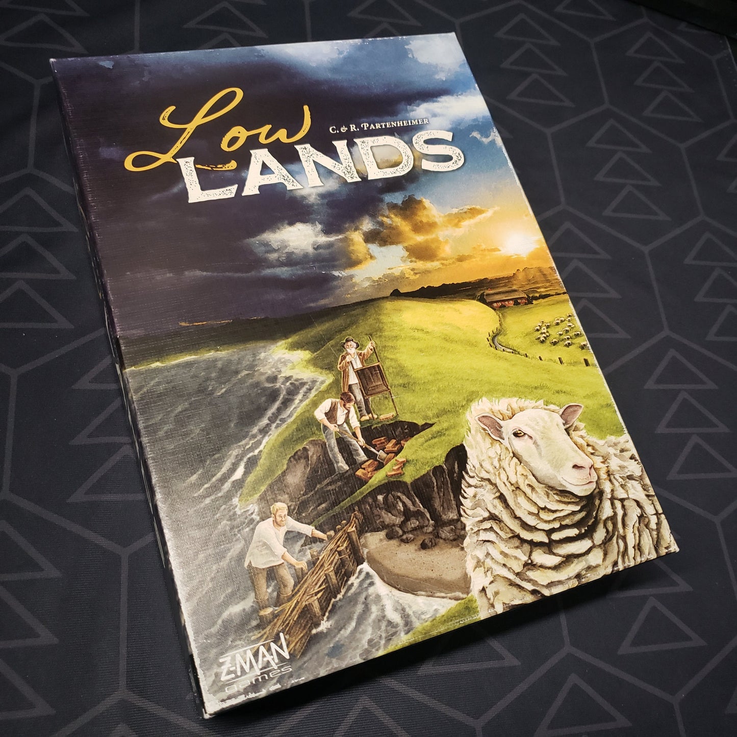 Image shows the front cover of the box of the Lowlands board game