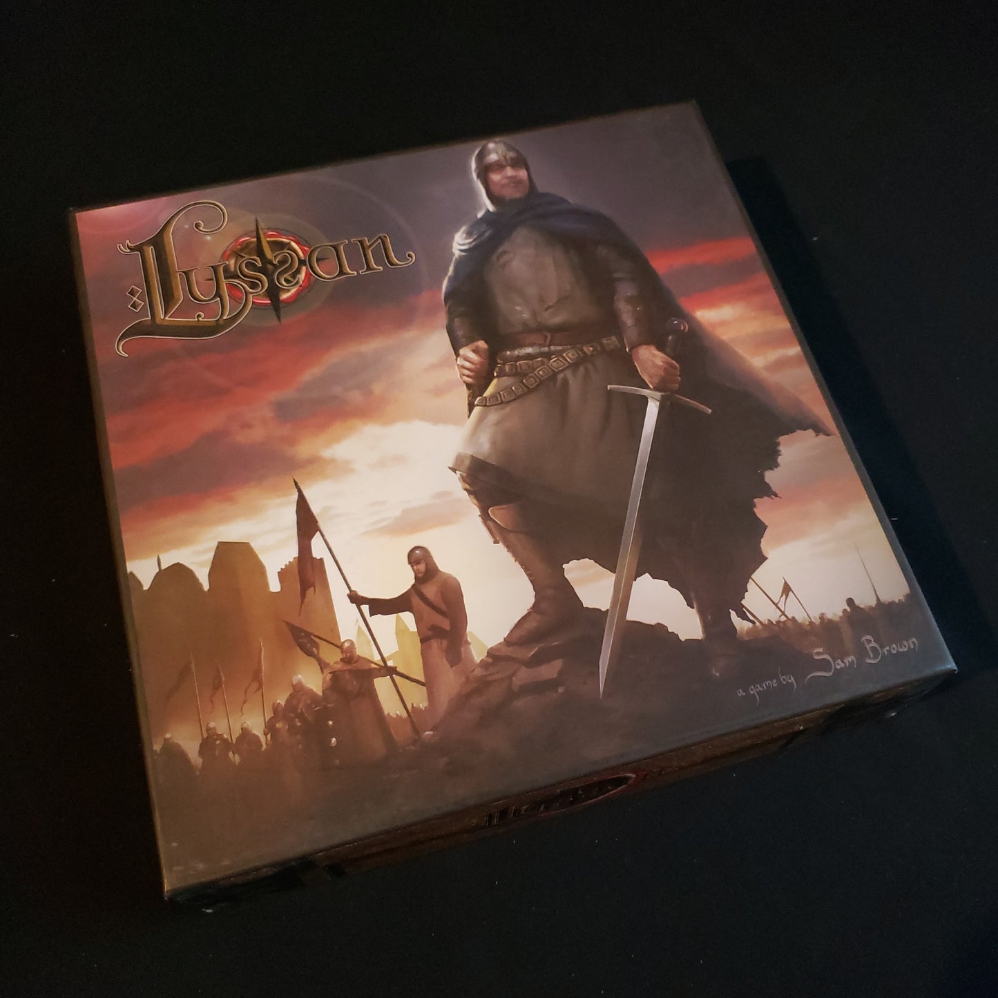 Image shows the front cover of the box of the Lyssan board game