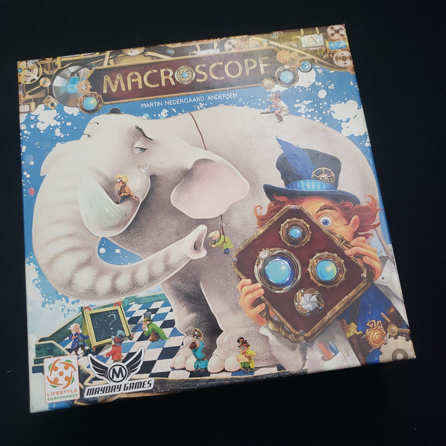 Image shows the front cover of the box of the Macroscope board game