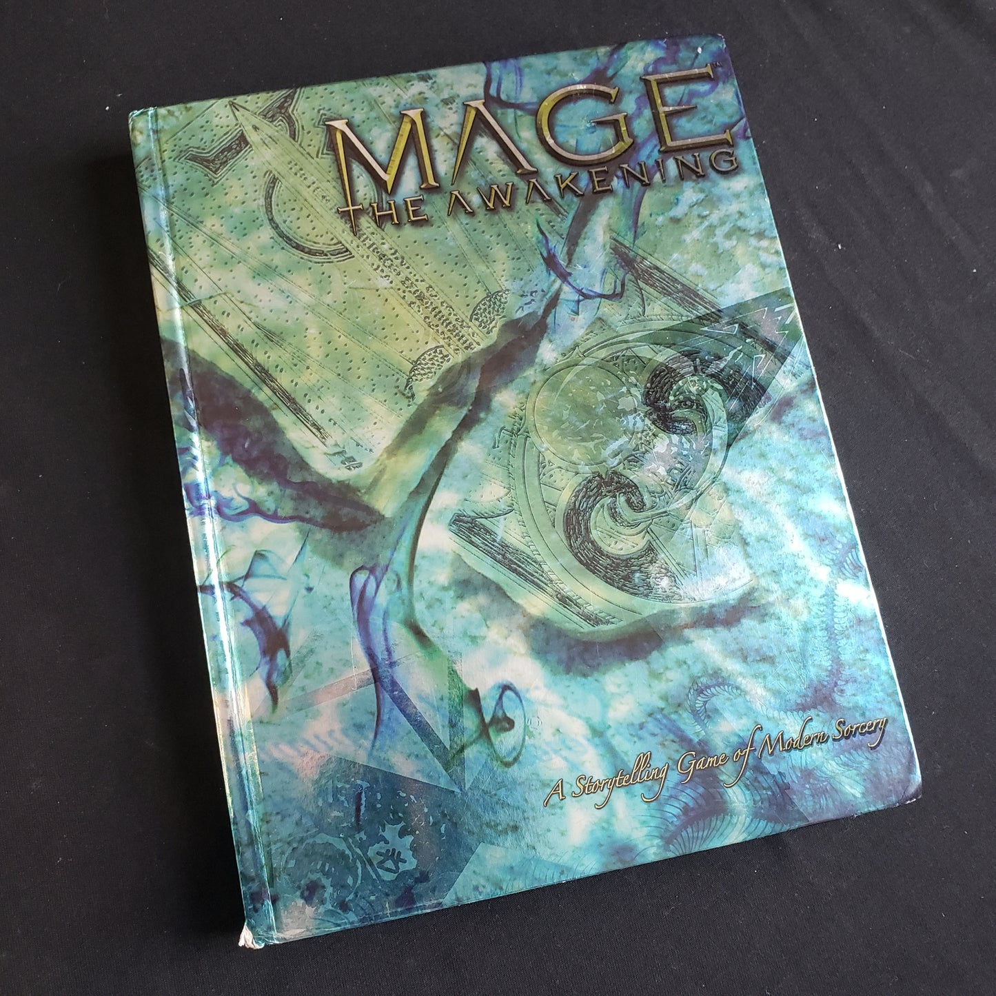 Image shows the front cover of the core rulebook for the Mage: The Awakening roleplaying game