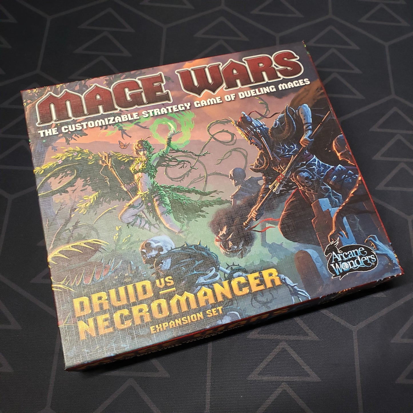 Image shows the front cover of the box of the Druid vs. Necromancer expansion for the board game Mage Wars