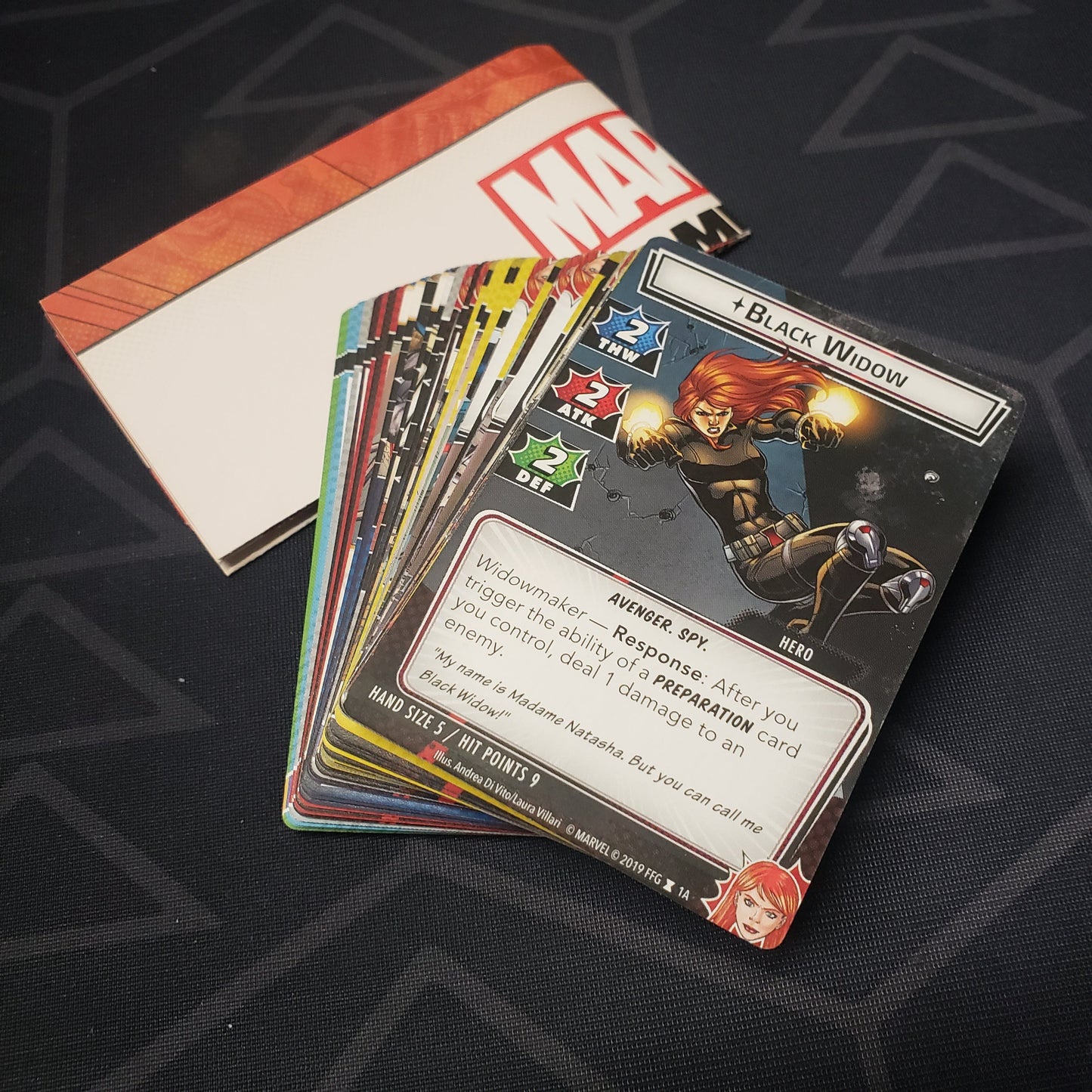 Image shows the instructions & cards fanned-out in a stack for the Black Widow Hero Pack from the Marvel Champions card game