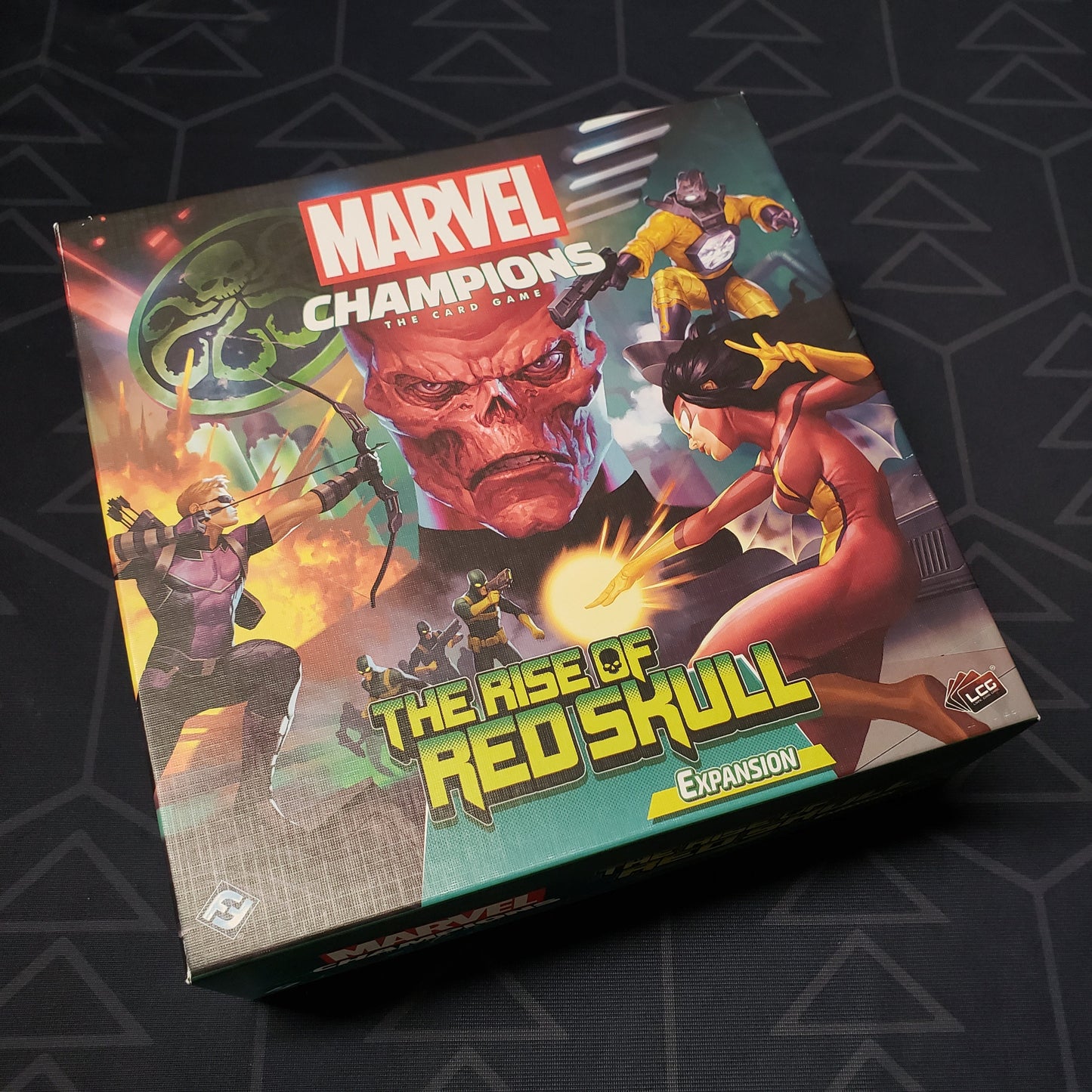 Image shows the front cover of the box of the Rise of Red Skull expansion for the card game Marvel Champions