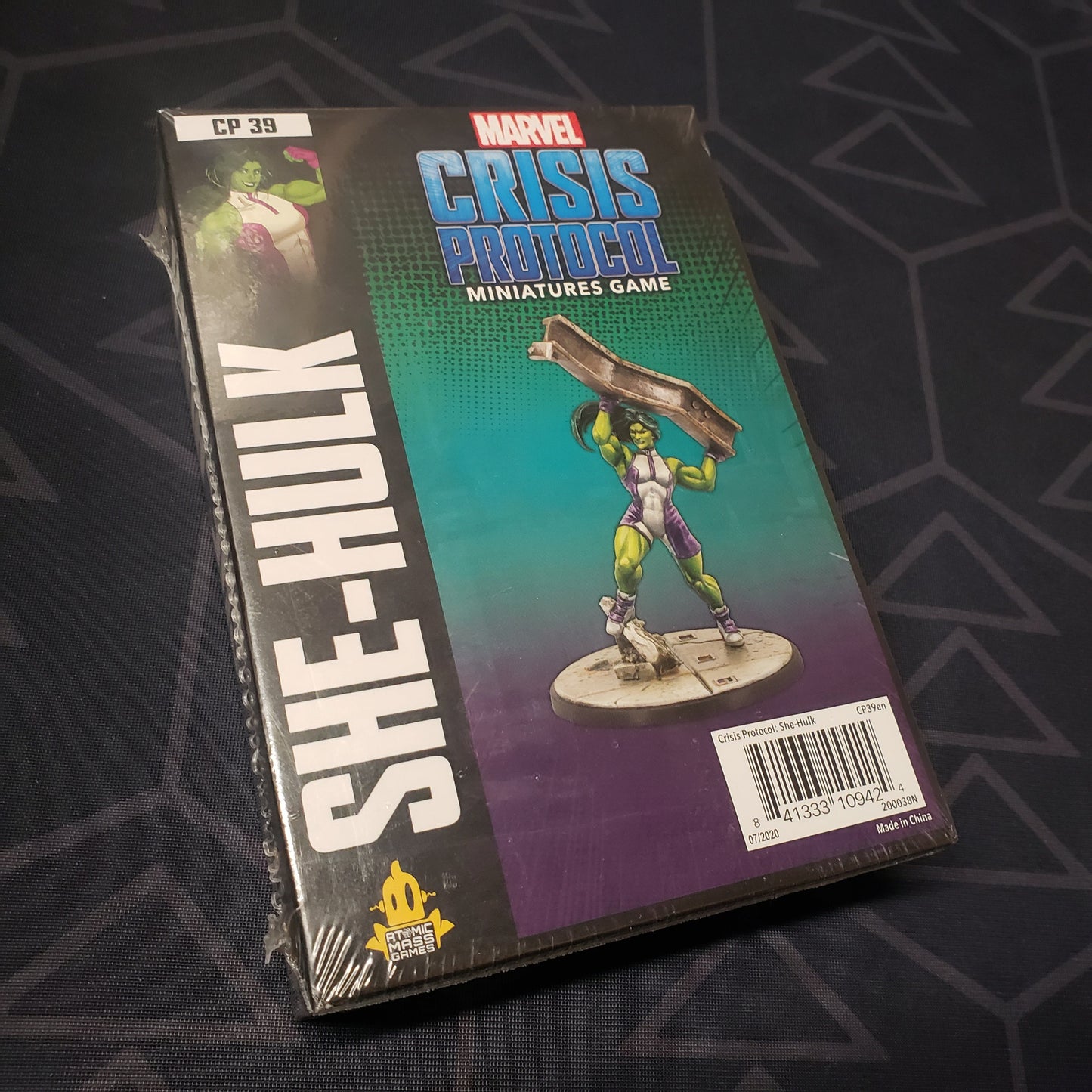 Image shows the front cover of the box of the She-Hulk pack for the miniatures game Marvel Crisis Protocol