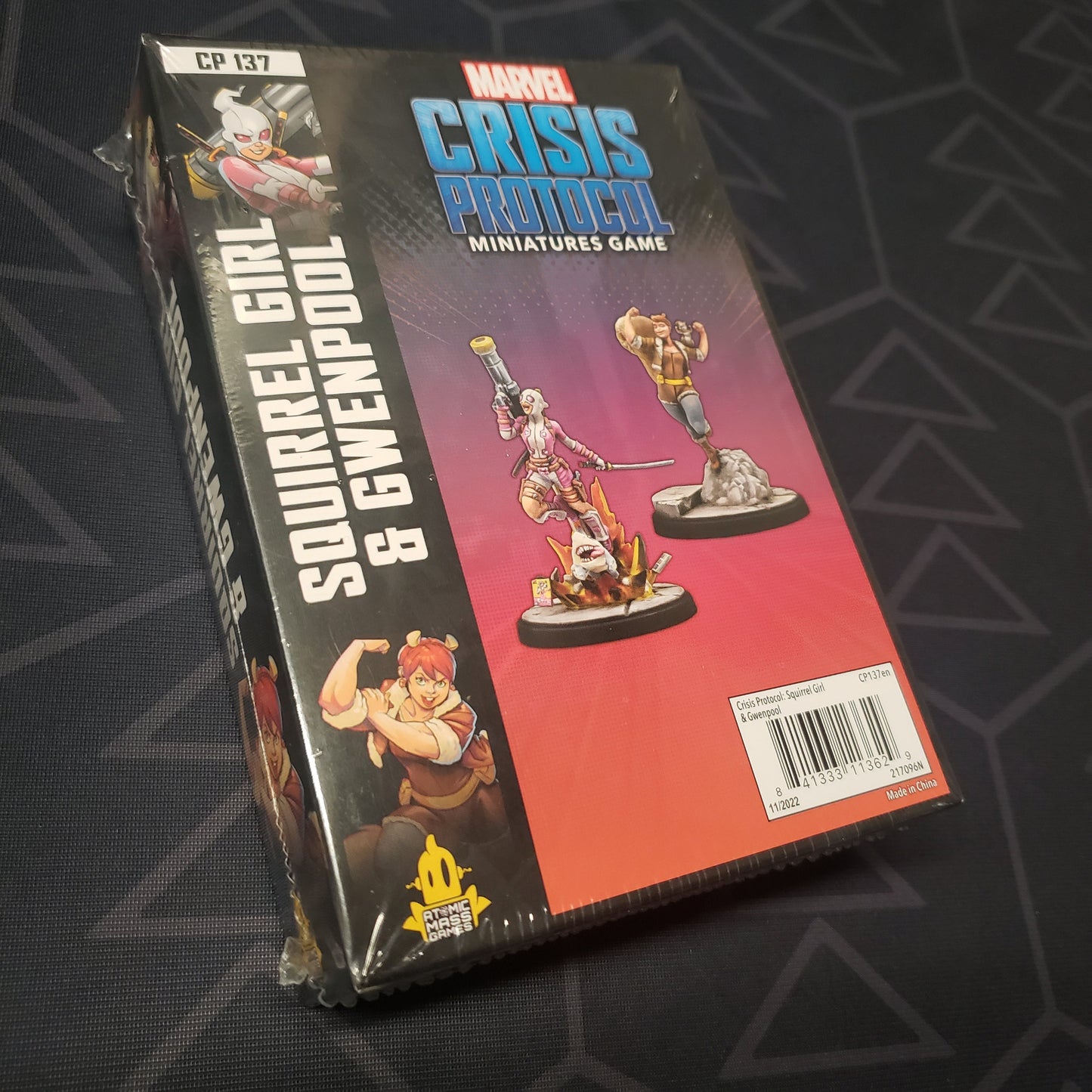 Image shows the front cover of the box of the Squirrel Girl & Gwenpool pack for the miniatures game Marvel Crisis Protocol