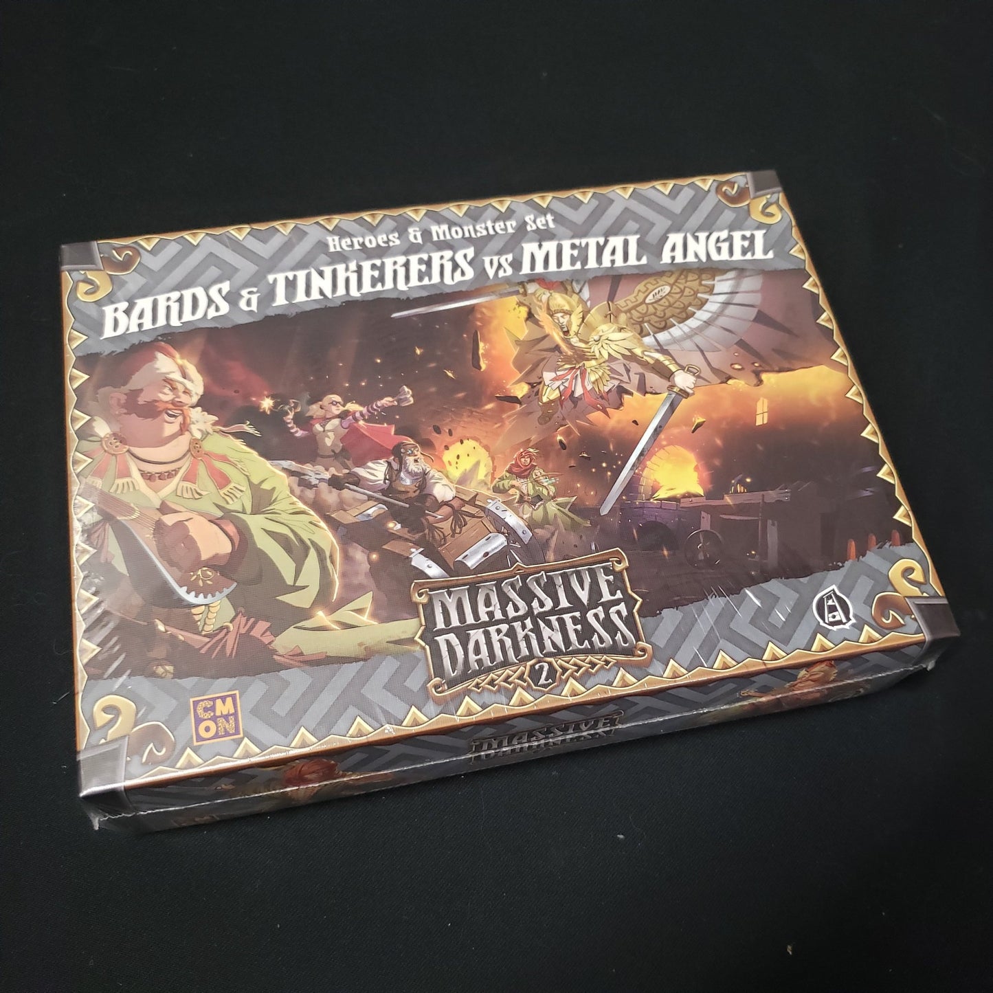 Image shows the front cover of the box of the Bards & Tinkerers vs Metal Angel expansion for the board game Massive Darkness 2: Hellscape