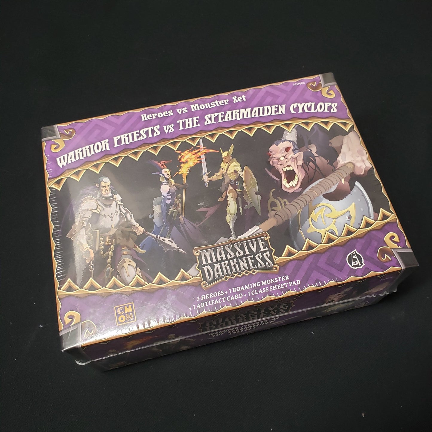 Image shows the front cover of the box of the Warriors Priests vs the Spearmaiden Cyclops expansion for the board game Massive Darkness