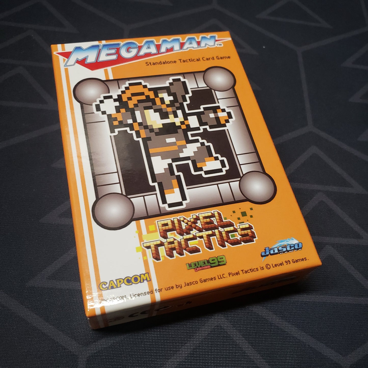 Image shows the front cover of the box for the Mega Man Pixel Tactics: Bass Orange card game