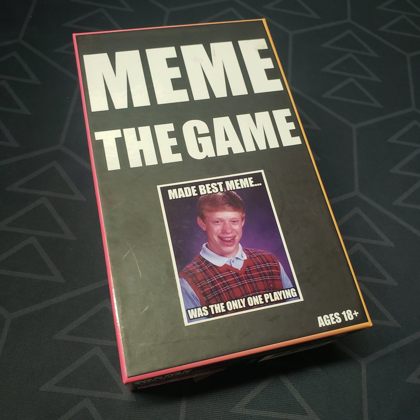 Image shows the front cover of the box for the Meme: The Game card game