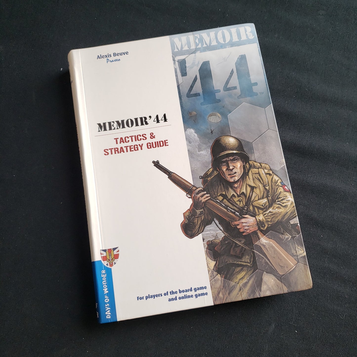 Image shows the front cover of the Tactics & Strategy Guide book for the Memoir 44 board game