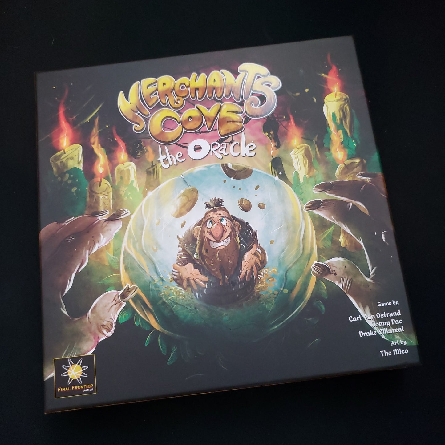 Image shows the front cover of the box of the Oracle expansion for the board game Merchants Cove
