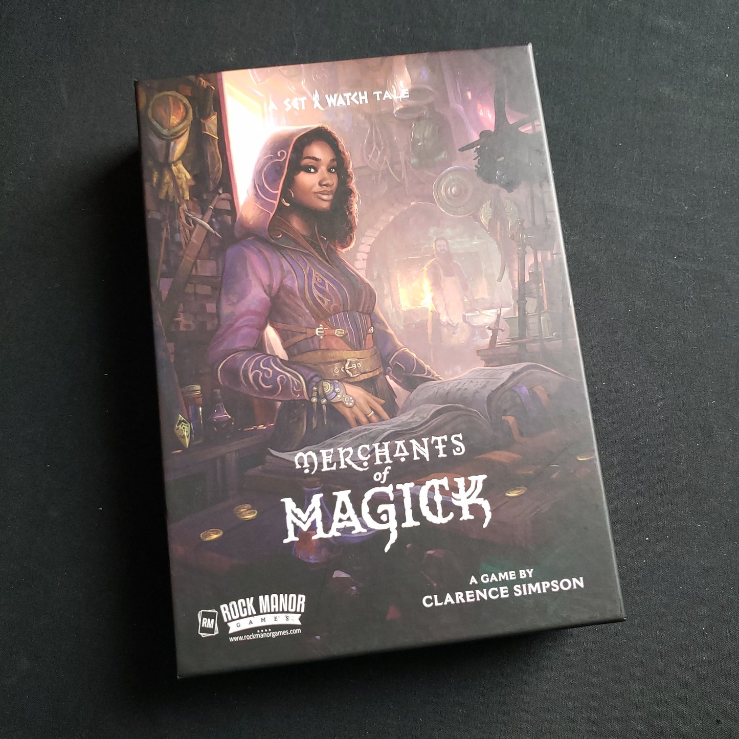 Image shows the front cover of the box of the Merchants of Magick board game