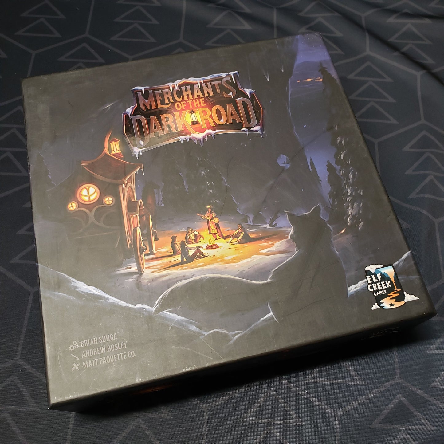 Image shows the front cover of the box of the Merchants of the Dark Road board game