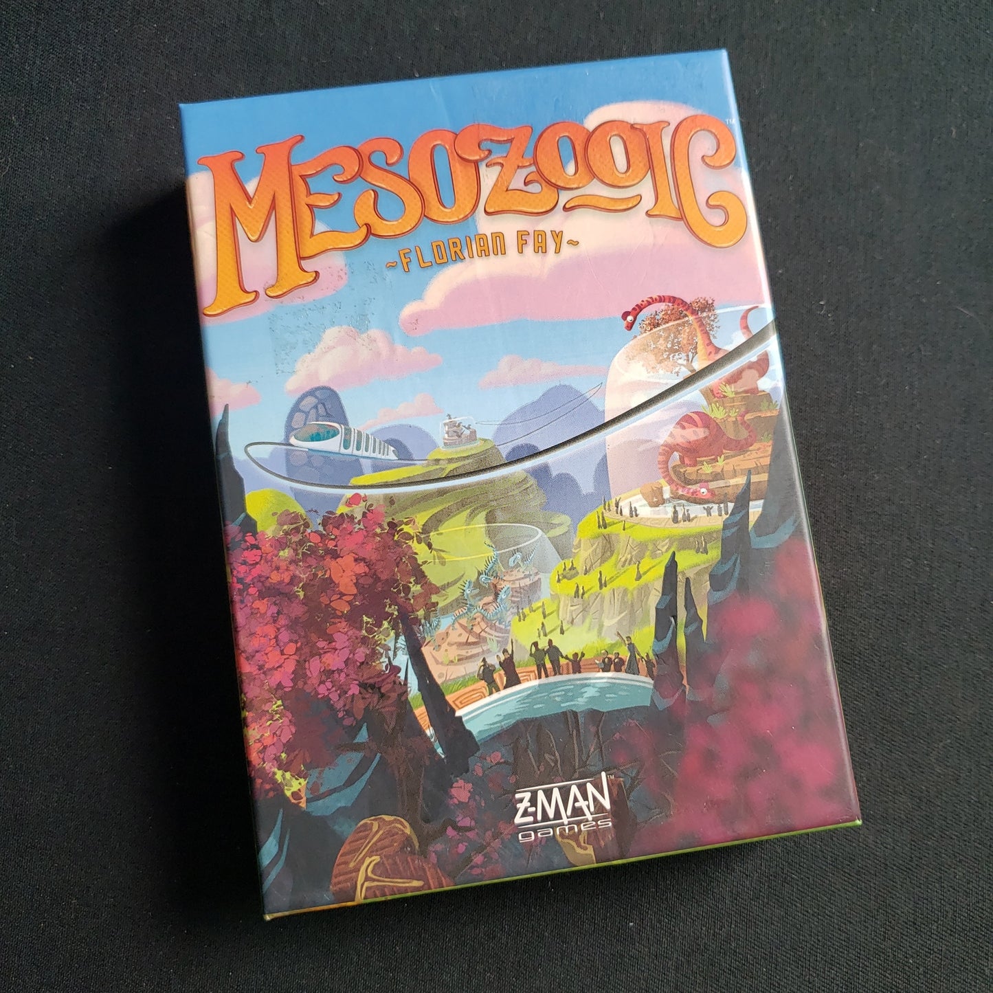 Image shows the front cover of the box of the Mesozooic card game