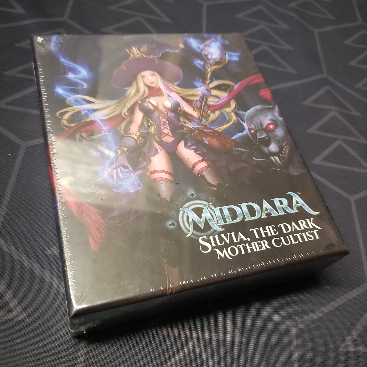 Image shows the front cover of the box of the Silvia, the Dark Mother Cultist expansion for the board game Middara