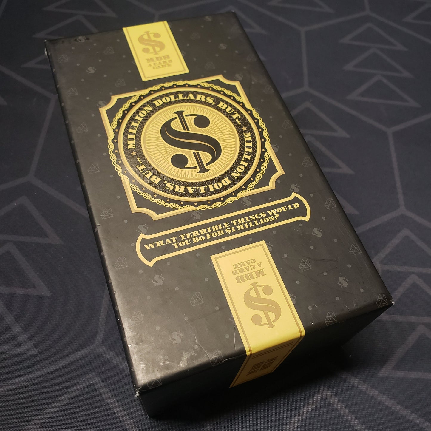 Image shows the front cover of the box for the Million Dollars, But... card game