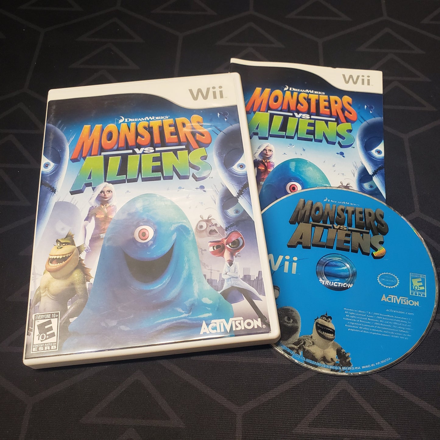Image shows the case, manual and disc for the video game Monsters vs Aliens for Nintendo Wii