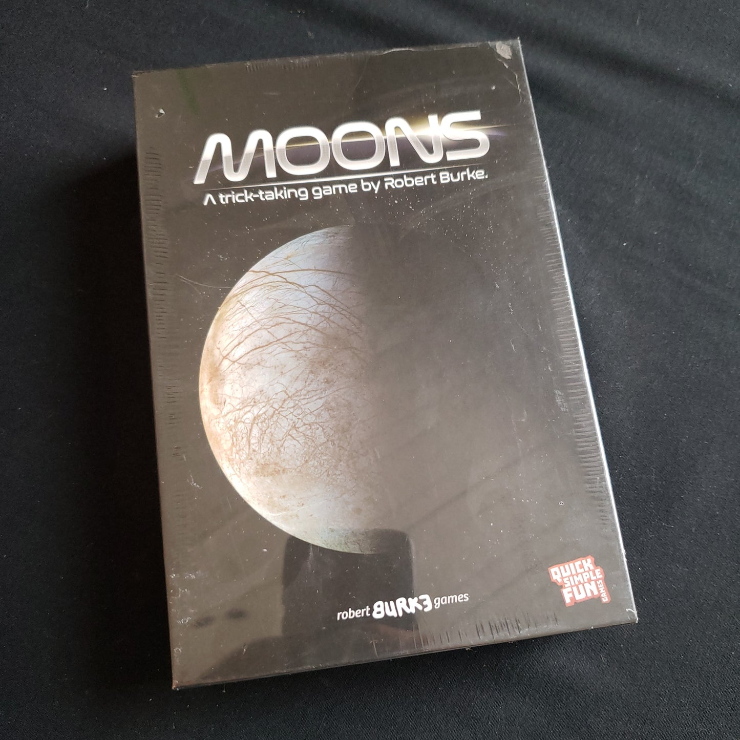 Image shows the front cover of the box of the Moons card game