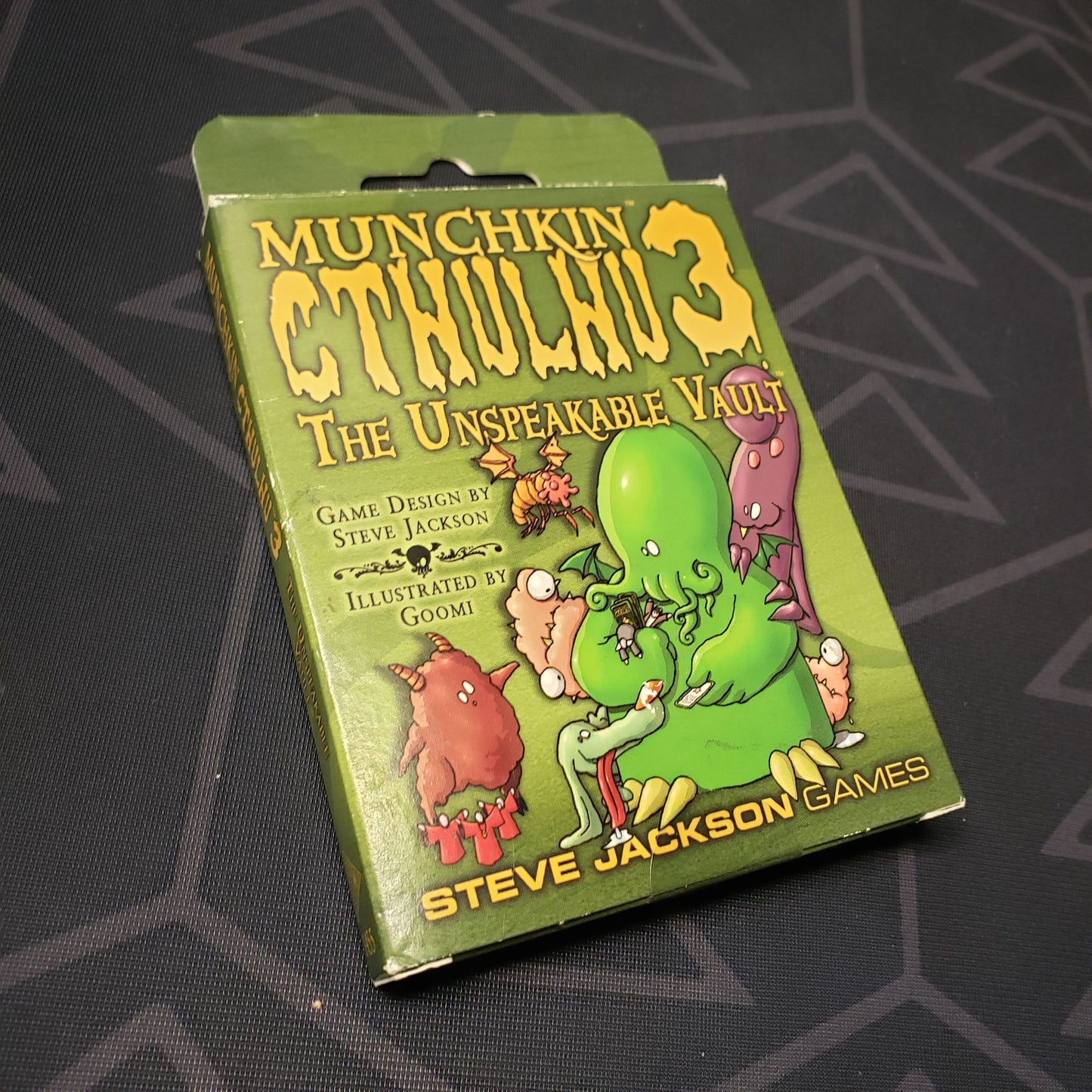 Image shows the front of the box for the Unspeakable Vault expansion for the card game Munchkin Cthulhu