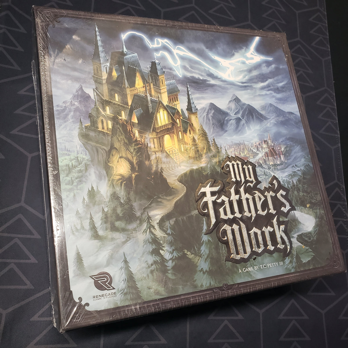 Image shows the front cover of the box of the board game My Father's Work