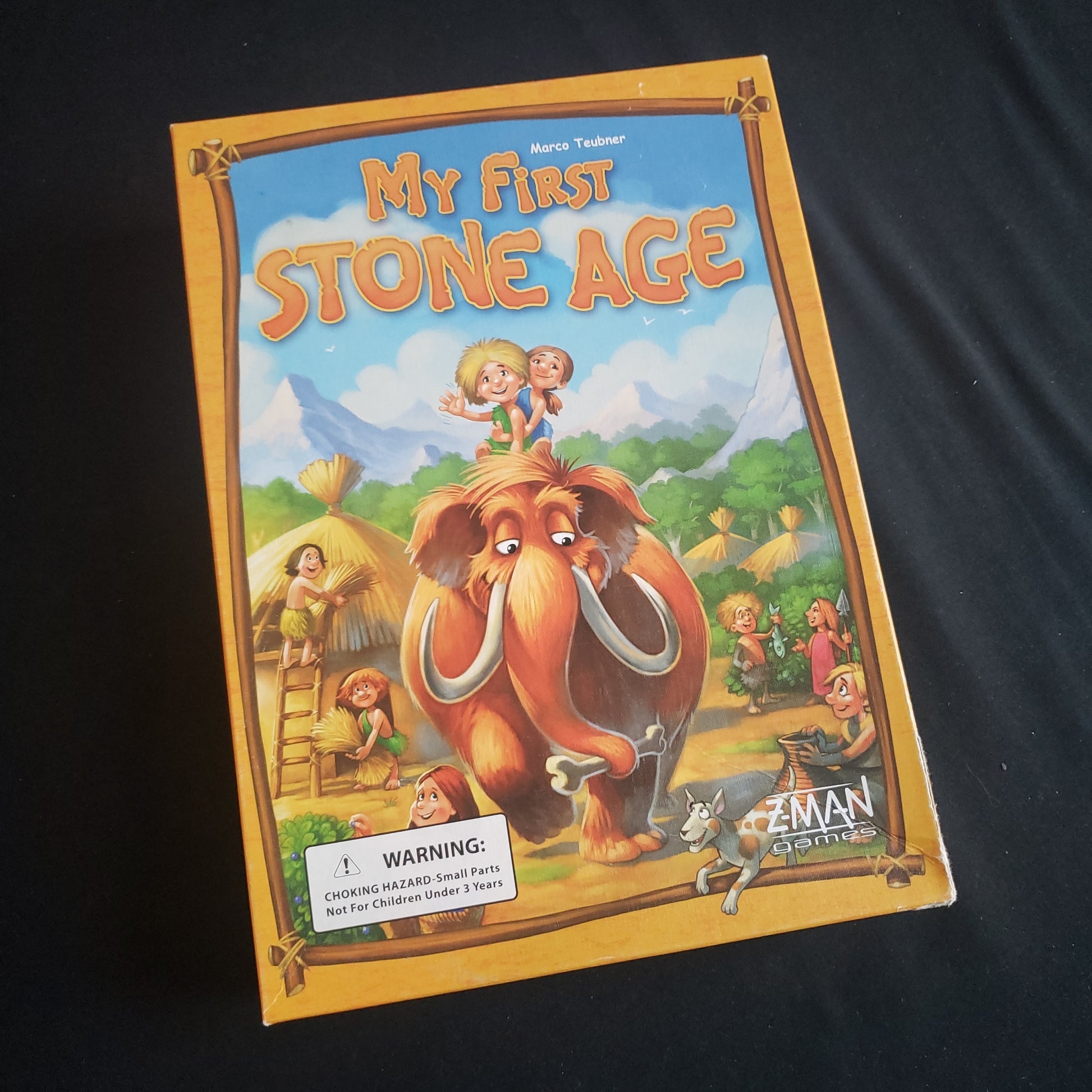 Image shows the front cover of the box of the My First Stone Age board game