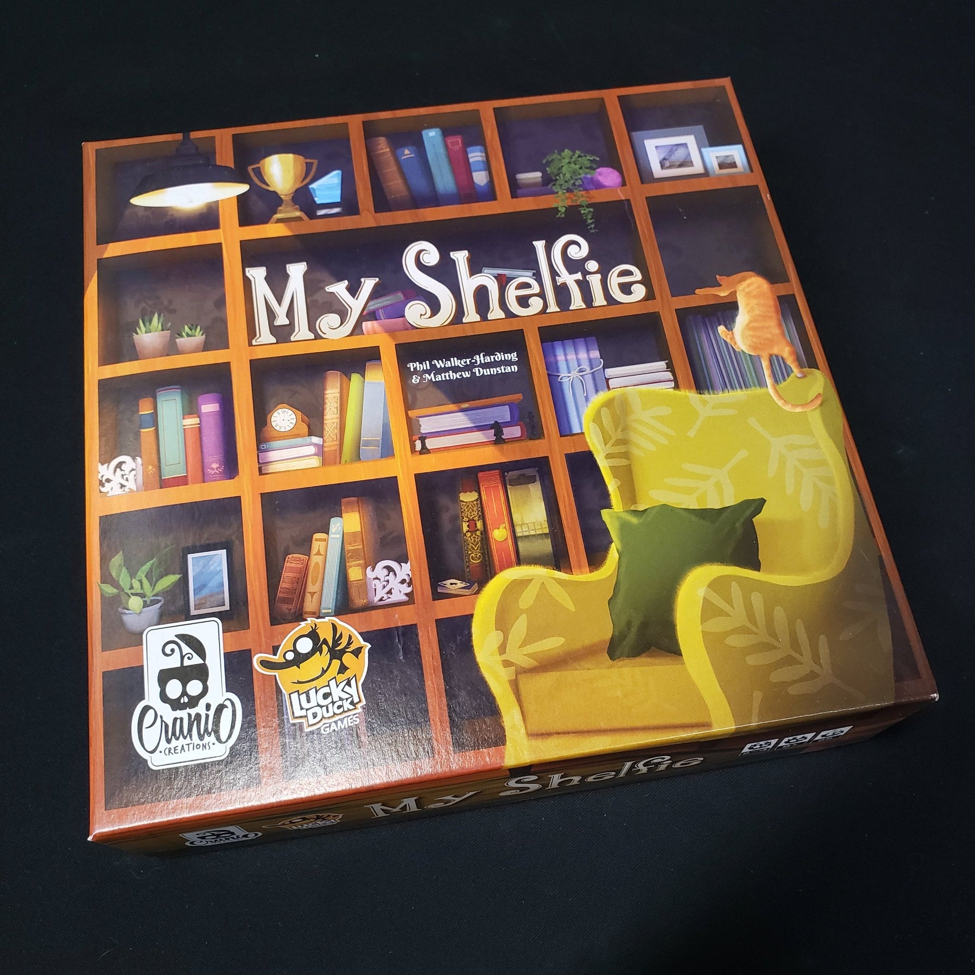 Image shows the front cover of the box of the My Shelfie board game