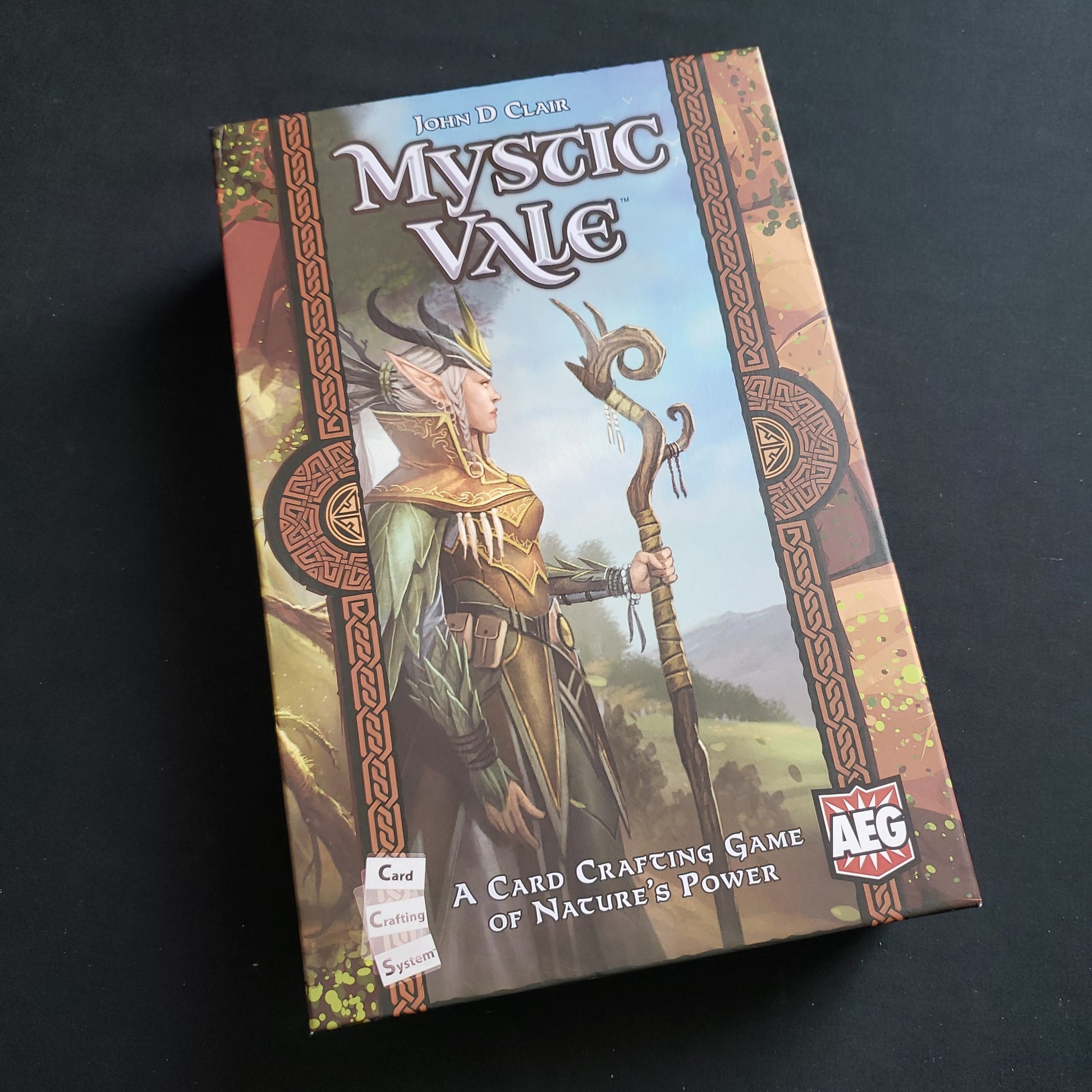 Image shows the front cover of the box of the Mystic Vale board game