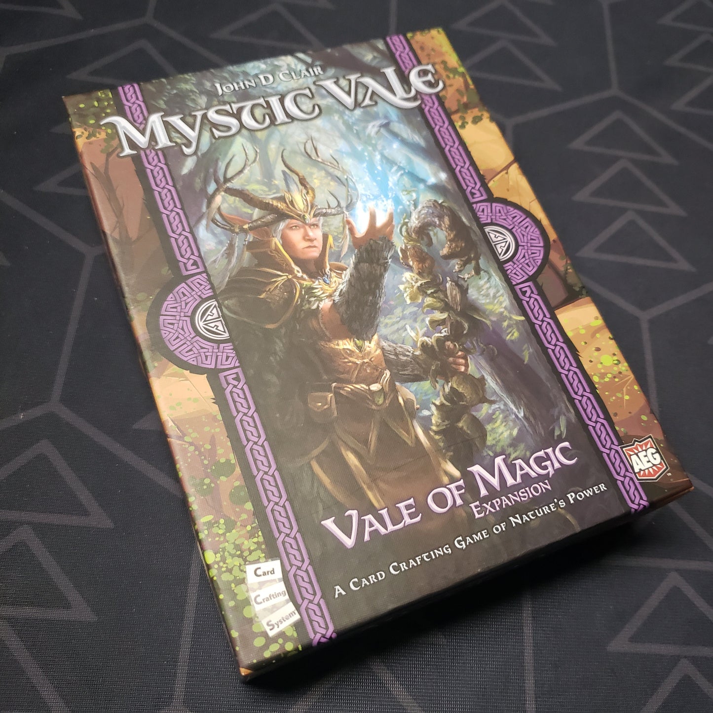 Image shows the front cover of the box of the Vale of Magic expansion for the card game Mystic Vale