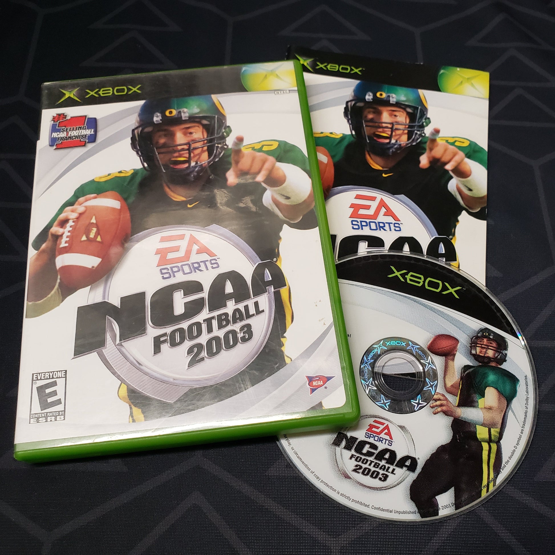 Image shows the case, manual and disc for the video game NCAA Football 2003 for the original Xbox