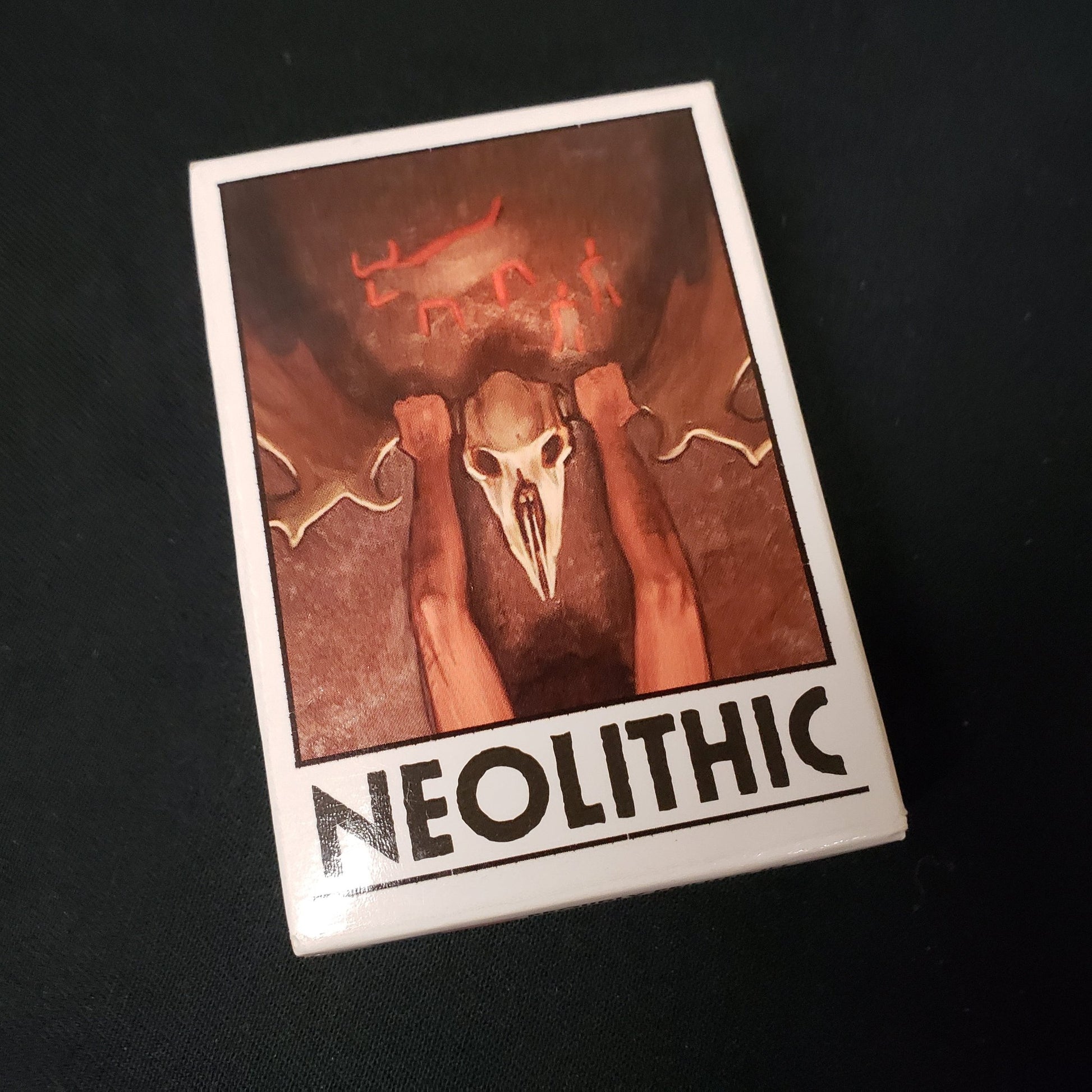 Image shows the front cover of the box of the Neolithic card game