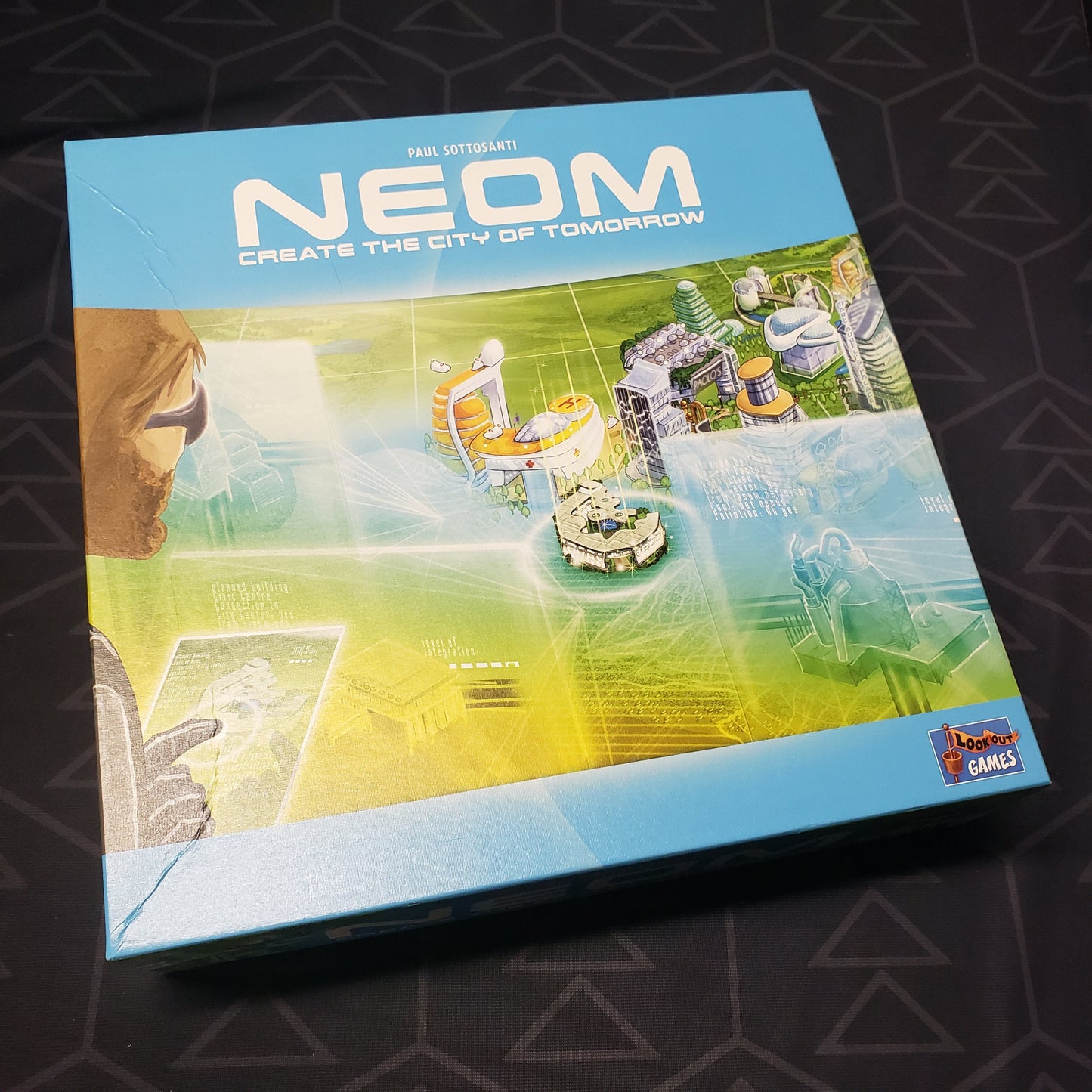 Image shows the front cover of the box of the NEOM board game