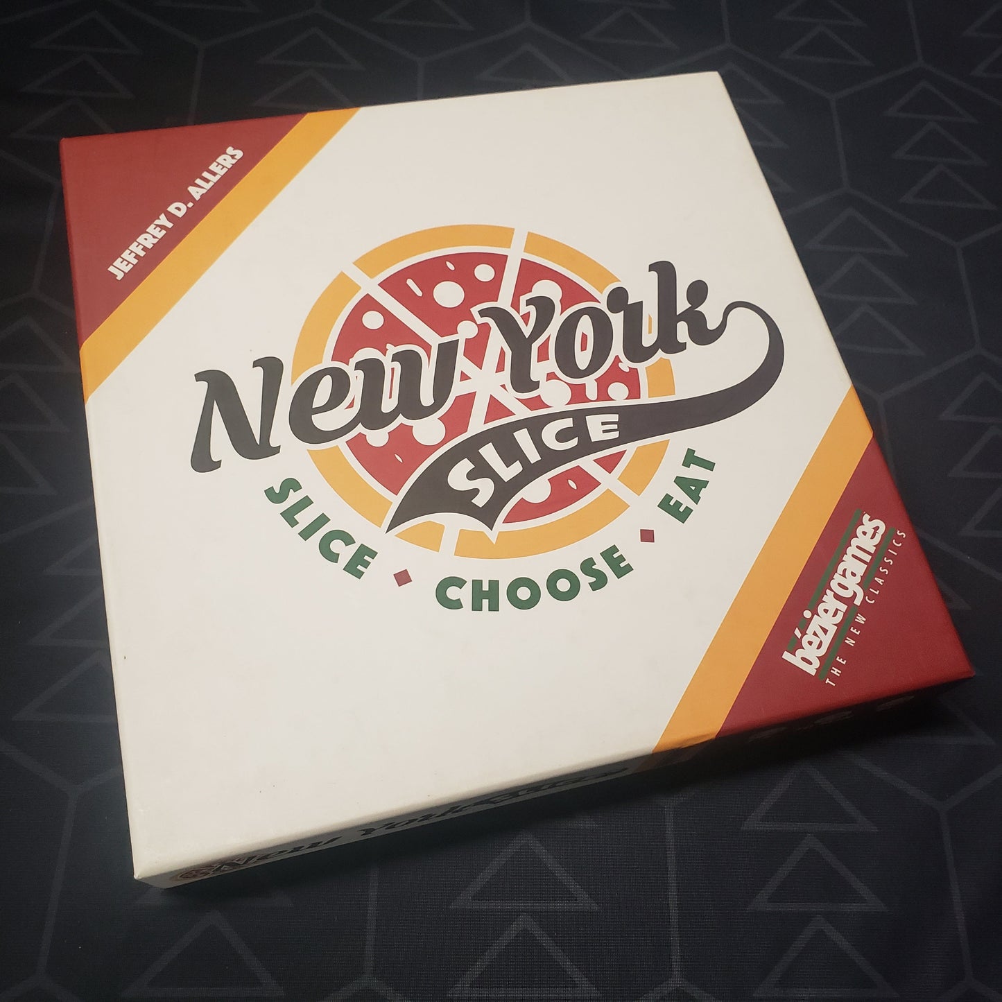 Image shows the front cover of the box of the New York Slice board game